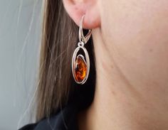 An elegant pair of Amber earrings featuring  simple marquise amber gemstones, framed in a shiny sterling silver frame. Material: Authentic Baltic Amber and .925 sterling silver Length: 23 mm x 10 mm ( 0.90 x 0.39 in ) Color: Cognac Finish: Polished The classic natural Amber earrings features marquise Amber gemstones sitting within a sterling silver open design. This classic lightweight accessory is perfect for daily or evening wear. Discover our exquisite Baltic Amber selection: https://www.etsy.com/ca/shop/AmberTresor?ref=seller-platform-mcnav All our products are handcrafted by professional artists with several years of experience in jewelry making. 100% Natural Baltic Amber with silver 925. -------------------------------------------------------------------- Amber is the fossilized resi Amber Gemstone, Amber Earrings, Amber Ring, Natural Amber, Amber Stone, Amber Jewelry, Open Design, Baltic Amber, Silver Frame