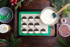 cookies are arranged on a cookie sheet with icing and sprinkles around them