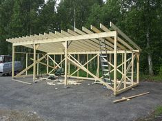 a large wooden structure sitting in the middle of a parking lot next to a truck