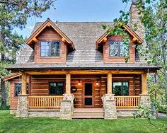 a log cabin sits in the middle of a grassy area surrounded by trees and grass