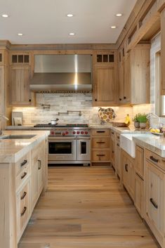 a large kitchen with wooden cabinets and stainless steel stove top oven in the center, along with hardwood flooring