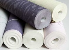 several rolls of white, purple and grey fabric