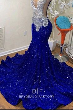 a blue dress with sequins on it is displayed in front of a mirror