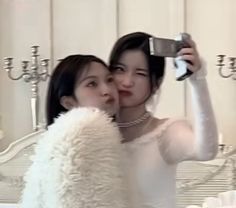 two women taking a selfie in front of a mirror