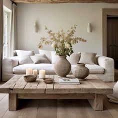 a living room filled with white furniture and lots of flowers on top of a wooden table