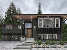 a modern house with lots of windows and steps leading up to the front door area