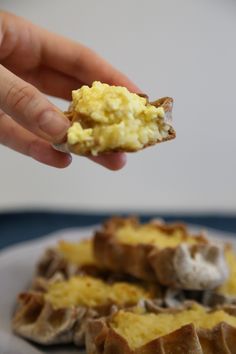 someone is holding up some kind of food on a plate with eggs and mushrooms in it