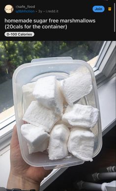 someone is holding a container full of marshmallows