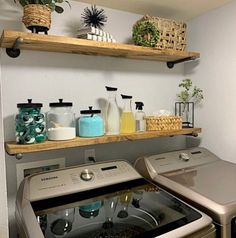 a washer and dryer in a small room with shelves above the washer