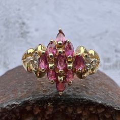 Gorgeous Rubies accented by Diamonds set in a Lovely 14k Yellow Gold Cluster Ring. US Size 7 3/4 Rubies approximately 1.1 ctw Diamonds 0.08 ctw, approximately  Diamond Grade: J / I Widest Point measures approximately 13.6 mm. Back of the shank tapers down to 2.1 mm, approximately. Nicely weighted at 3.6 grams, approximately. Stamped 14K Ruby is the birthstone for July. Diamond is the birthstone for April. Cubic Zirconia Marquise-cut Multi-stone Diamond Ring, Marquise Cut Multi-stone Cubic Zirconia Diamond Ring, Multi-stone Cubic Zirconia Marquise Cut Ring, Marquise Cut Multi-stone Diamond Ring For Anniversary, Classic Diamond Ring With Multi-stone Marquise Cut, Classic Multi-stone Marquise Cut Diamond Ring, Classic Marquise Cut Multi-stone Diamond Ring, Cluster Diamond Ring With Vvs Clarity And Ruby, Marquise Multi-stone Cluster Ring For Anniversary