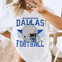 a woman taking a selfie in front of a mirror wearing a football t - shirt