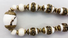 "This custom handmade necklace was made by jewelry artist Jacki Marsh. The beautiful white beads and the white beads with the brass caps in this necklace are sacred chank shells from Tibet / Nepal. Sacred chank shell (Turbinella Pyrum Linne) has been revered for thousands of years, since at least 2000 B.C. Chank shell is revered in Tibet, India, Nagaland and China. It is used by Hindus and Buddhists in rites and religious ceremonies. Tibetan men and women wear jewelry all of their lives for ador Vintage White Beaded Necklace For Festivals, White Gemstone Beads Jewelry For Festival, White Round Spiritual Beaded Necklaces, Hand-strung White Round Bead Necklaces, White Round Spiritual Beaded Necklace, White Round Beaded Spiritual Necklace, White Hand-strung Round Bead Necklaces, Spiritual White Round Beaded Necklaces, White Round Beaded Necklaces For Spiritual Occasions