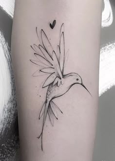 a black and white photo of a humming bird tattoo on the right side of the leg