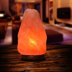 a himalayan salt lamp sitting on top of a wooden table in front of a living room