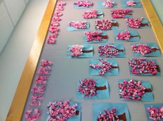 a bulletin board decorated with pink and blue paper flowers on the front, and words that spell happy