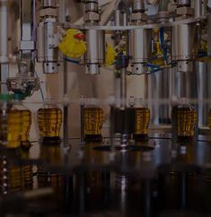 some yellow cups are sitting in front of a machine that is filling them with liquid