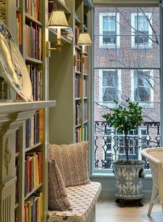 a living room filled with lots of furniture and bookshelves next to a window