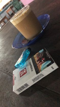 a cup of coffee sitting on top of a blue plate next to a paper ticket