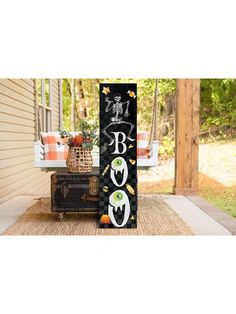 a black and white sign sitting on the side of a house next to a trunk