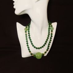 On offer is this spectacular Vintage Chinese 36 Inches Long Green Nephrite Jade Beaded Necklace with 14 Karat Yellow Gold Corrugated Spacer Beads and a huge roung central Hand Carved and Pierced Translucent Green Jade Pendant with Two Shou Design Carved Green Jade Beads.  The necklace is hand knotted with green silk cord with no clasp because it easily slips over your head.  The green Nephrite Jade is highly polished so it gleams with a deep luster.  The Nephrite Jade beads measure 8mm in diamet Antique Carved Jade Pendant And Beaded Necklace, Elegant Green Onyx Beaded Necklaces, Elegant Aventurine Beaded Necklace With Polished Beads, Elegant Aventurine Beaded Necklaces With Polished Beads, Elegant Green Hand-strung Necklace, Green Jade Necklace With 108 Beads, Green Single Strand Aventurine Jewelry, Elegant Jade Beads For Jewelry Making, Green Jade Long Necklace