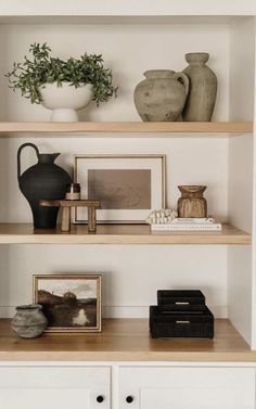 some shelves with vases and pictures on them