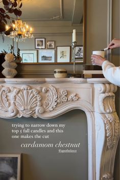 a woman is holding a cup in front of a fireplace with a quote on it