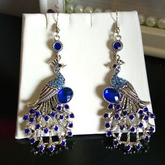 Cobalt Blue And Silver Dangled Peacock Earrings Measuring 2.5 In Long. Metal Jewelry With Peacock Design For Party, Party Jewelry With Peacock Design In Metal, Silver Peacock Design Jewelry For Party, Party Earrings In Peacock Color, Peacock Design Dangle Chandelier Earrings Gift, Elegant Metal Jewelry With Peacock Design, Silver Peacock Design Earrings For Party, Party Peacock Design Dangle Earrings, Elegant Silver Earrings With Peacock Design