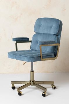 a blue office chair sitting on top of a white floor next to a beige wall