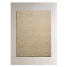 a beige rug on top of a white wall