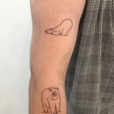 a man's arm with two small tattoos on it, one has a polar bear and the other has a penguin