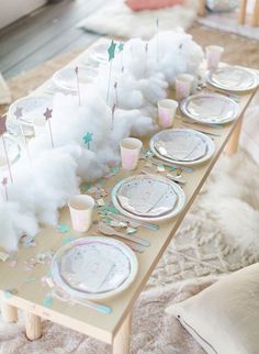 a table set up for a birthday party with clouds and stars on the table top