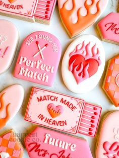 some pink and orange decorated cookies are on a table with other cookie decorations in the shape of hearts