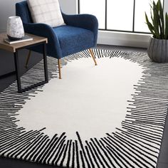 a white rug with black lines on it in a room next to a blue chair