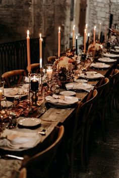 a long table is set with candles and plates