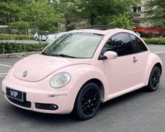 a pink car parked in a parking lot