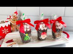 three christmas treats wrapped in cellophane and tied with red ribbon on a tray