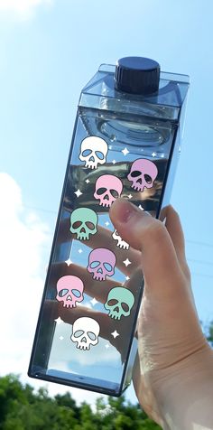 a hand holding a water bottle with skulls on it