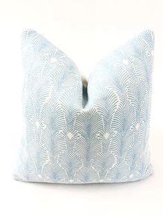 a blue and white decorative pillow on a white background