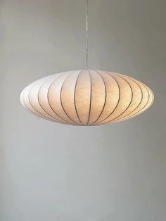 a light fixture hanging from a ceiling in a room with gray walls and flooring