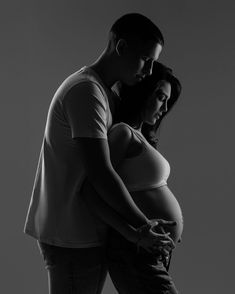 black and white photograph of a pregnant woman with her belly wrapped around the man's waist