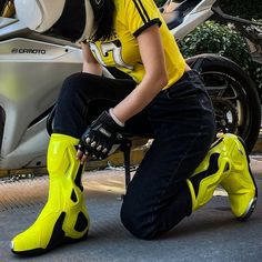 a woman sitting on a motorcycle wearing yellow boots