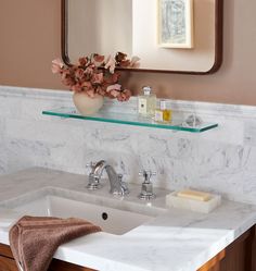 a bathroom sink with a mirror above it and a towel on the counter next to it