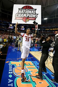 a basketball player holding up a sign in the air