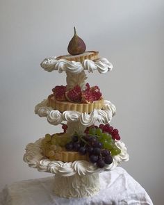 a three tiered cake with fruit on top