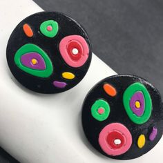 ON SALE Vintage colorful green pink black painted wooden pierced earrings in very good vintage condition. One and a quarter inches round. Very nice color combination perfect for any retro outfit. Retro Multicolor Hand Painted Earrings, Retro Hand Painted Multicolor Earrings, Multicolor Round Clip-on Earrings, Retro Multicolor Clip-on Earrings, Retro Black Round Earrings, Vintage Multicolor Round Clip-on Earrings, Retro Outfit, Desert Hot Springs, Lucite Jewelry