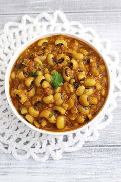 a white bowl filled with beans and meat