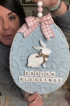 a woman holding up an easter egg with a bunny on it and the words easter, blessing