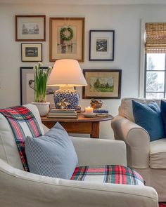 a living room filled with furniture and framed pictures on the wall above it's windows