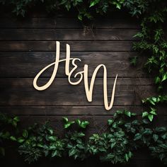 the word h & m spelled with wood letters surrounded by green leaves on a wooden background