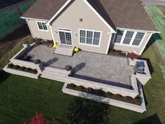 an aerial view of a house with a large patio and steps leading to the front door